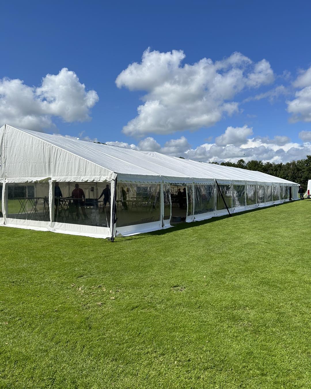 Eight shirts arranged on table in black, olive, grey, blue, white, red, mustard, and green.