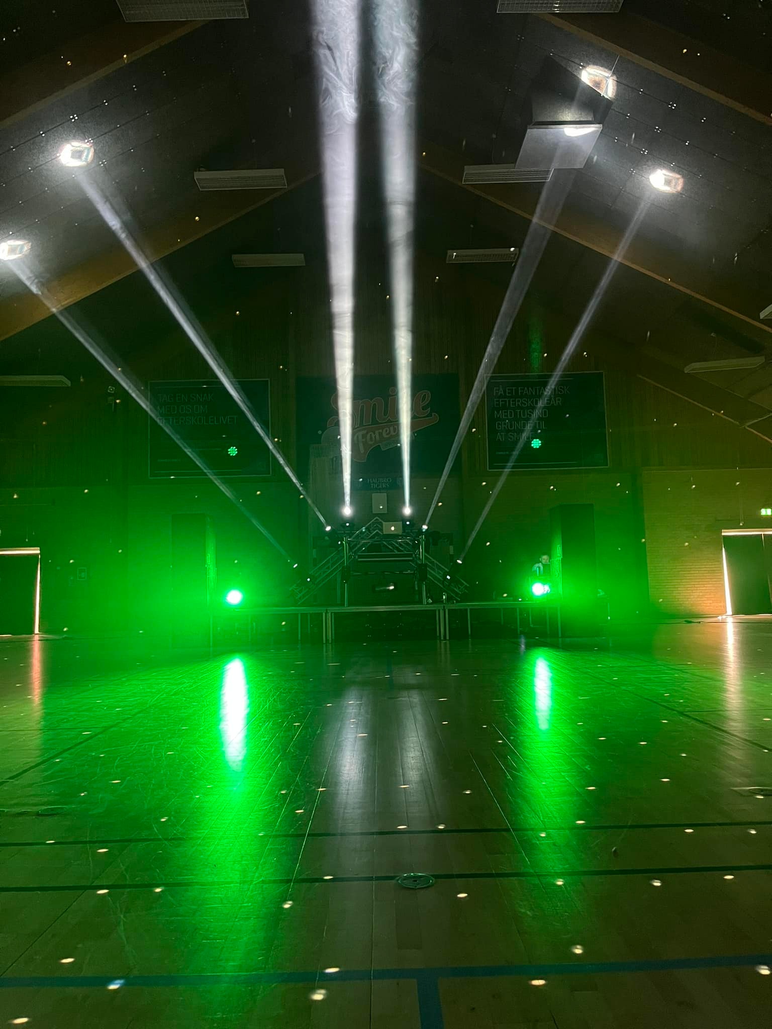 Eight shirts arranged on table in black, olive, grey, blue, white, red, mustard, and green.