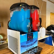 Eight shirts arranged on table in black, olive, grey, blue, white, red, mustard, and green.