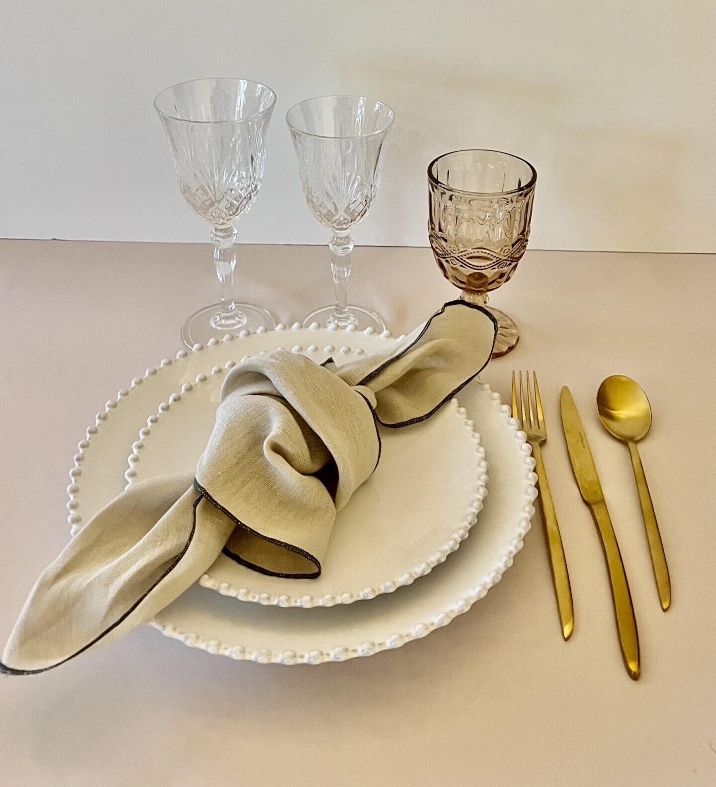 Eight shirts arranged on table in black, olive, grey, blue, white, red, mustard, and green.