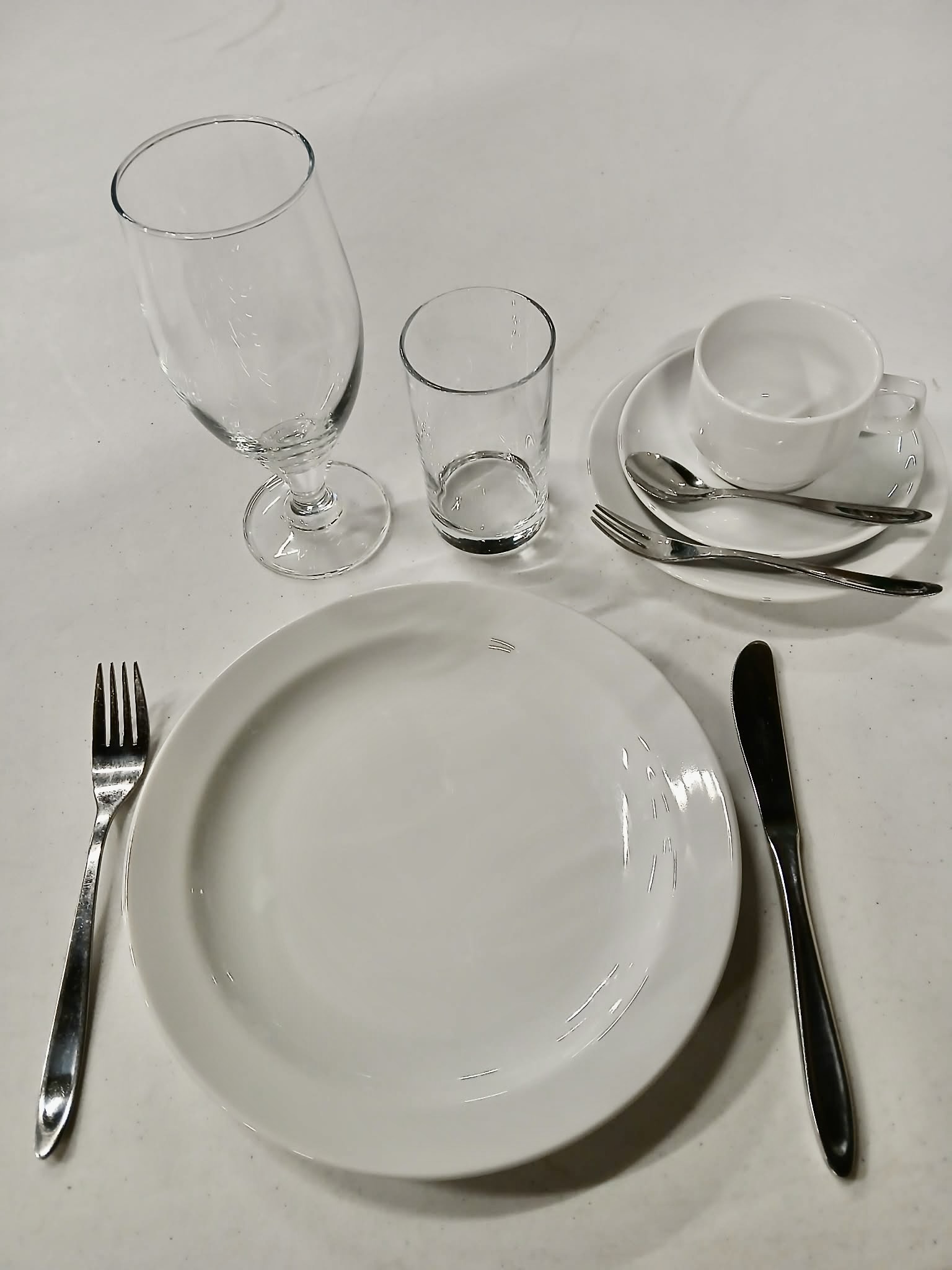 Eight shirts arranged on table in black, olive, grey, blue, white, red, mustard, and green.