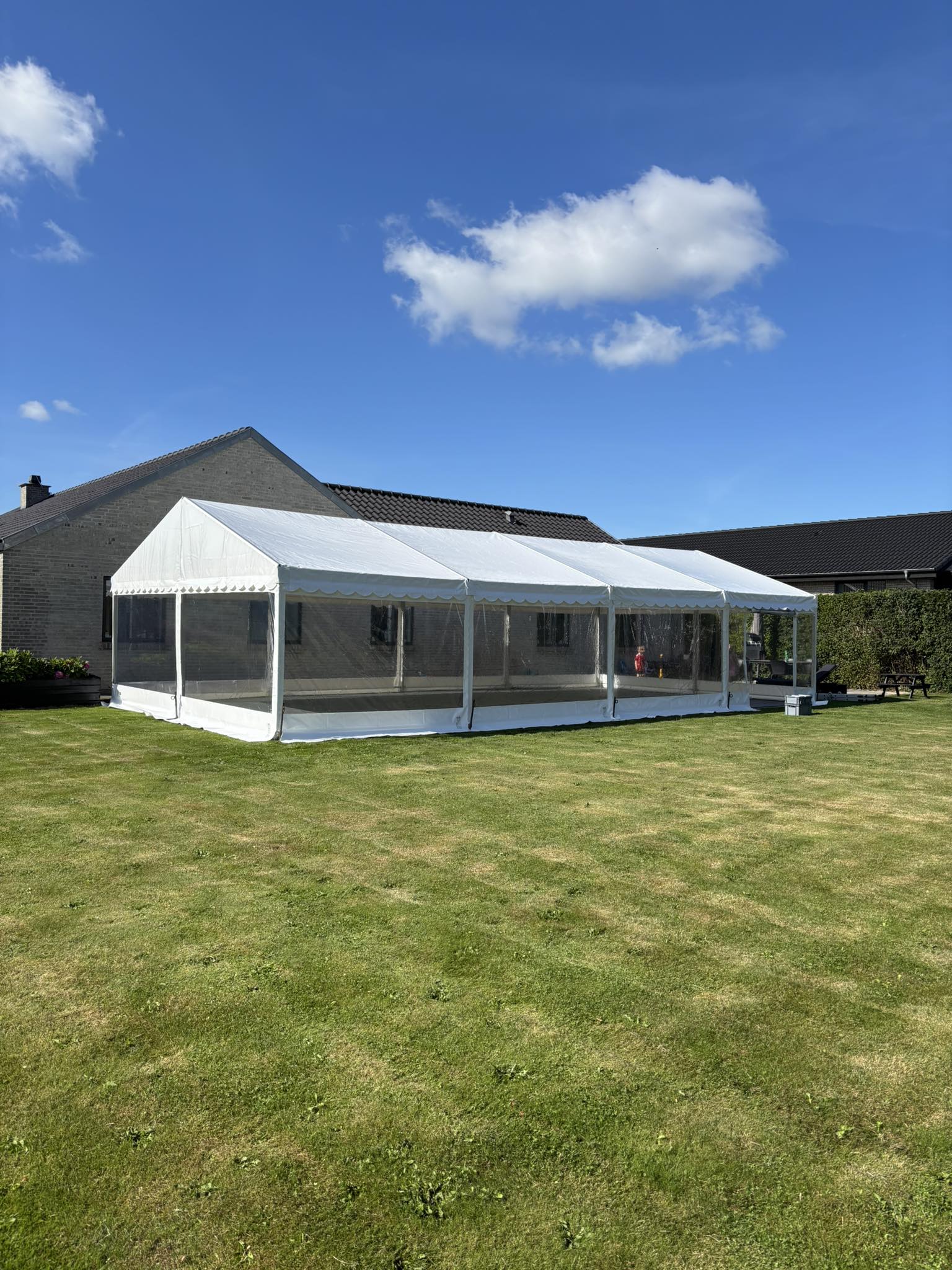 Eight shirts arranged on table in black, olive, grey, blue, white, red, mustard, and green.