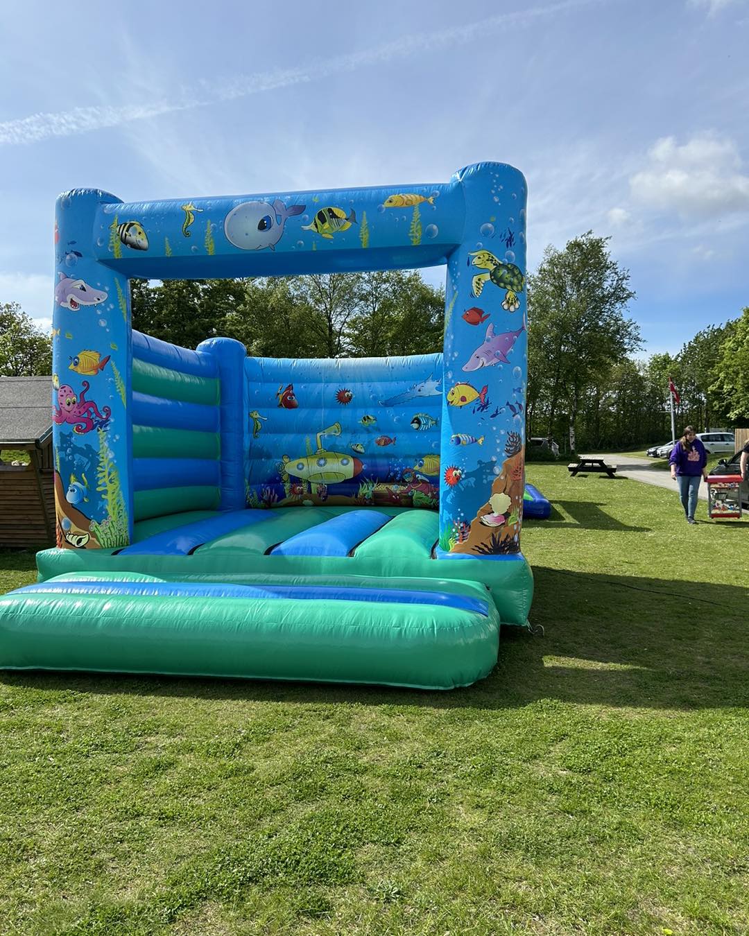 Eight shirts arranged on table in black, olive, grey, blue, white, red, mustard, and green.